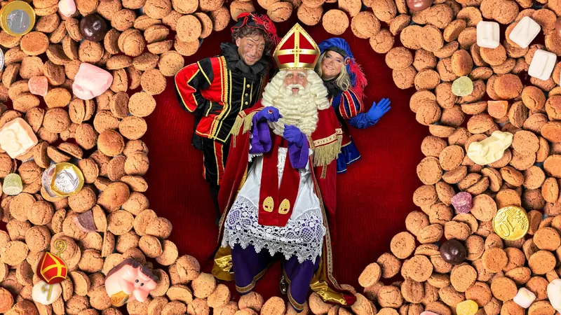 Sinterklaas met twee Pieten tussen de pepernoten