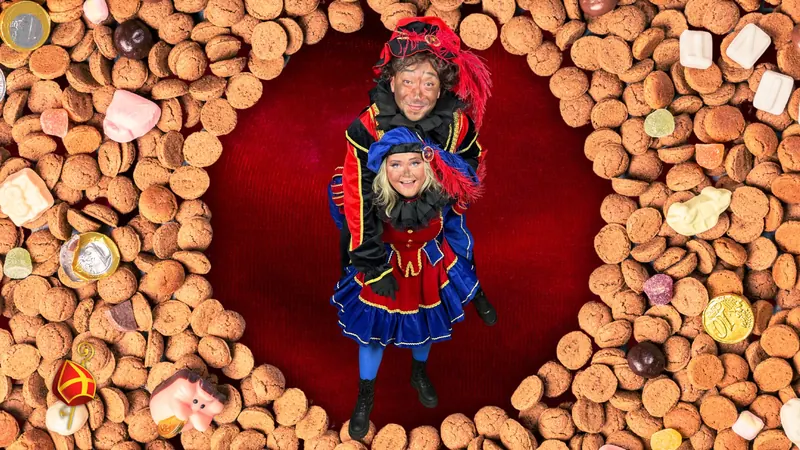Twee Pieten poseren samen tussen de pepernoten